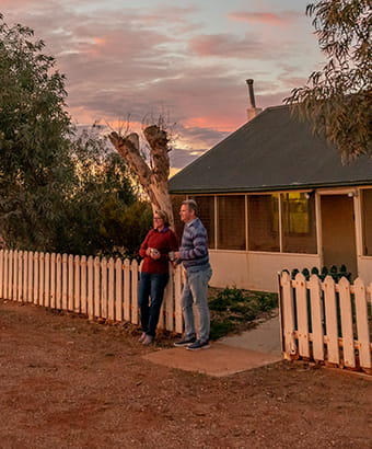 A couple watch an outback sunset outside Mount Wood Homestead, Sturt National Park. Photo: John Spencer/DPIE