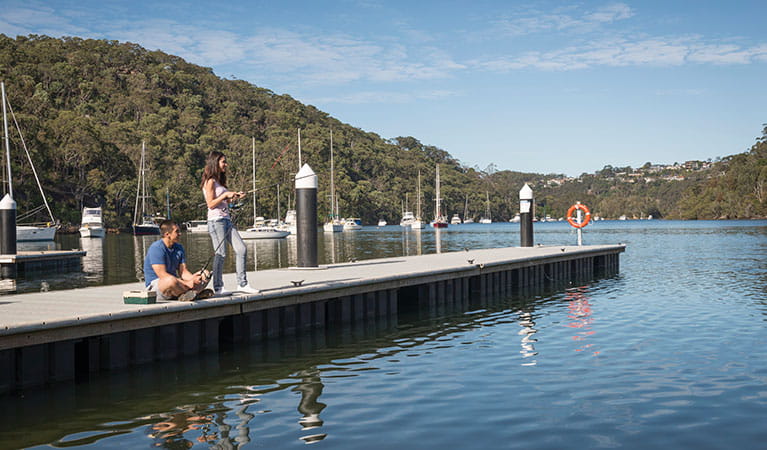 2 friends fishing on the wharf at Davidson Park picnic area in Garigal National Park. Photo: John Spencer/DPIE